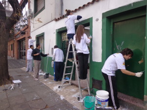 Los voluntarios pintando la fachada del Centro de Jubilados